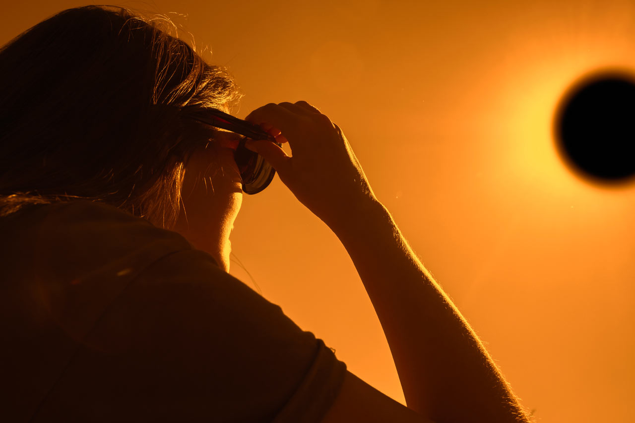A Woman looking at the solar eclipse with special glasses